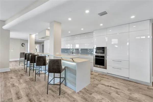a kitchen with stainless steel appliances kitchen island granite countertop a refrigerator and cabinets