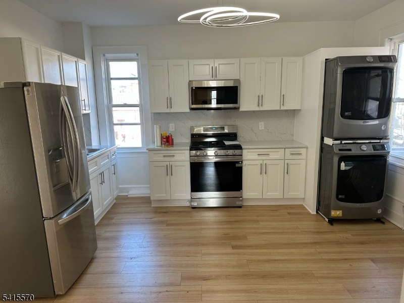 186 Main Avenue Passaic, NJ 07055 - Photo 13 of 13 a kitchen with granite countertop a refrigerator stove and microwave