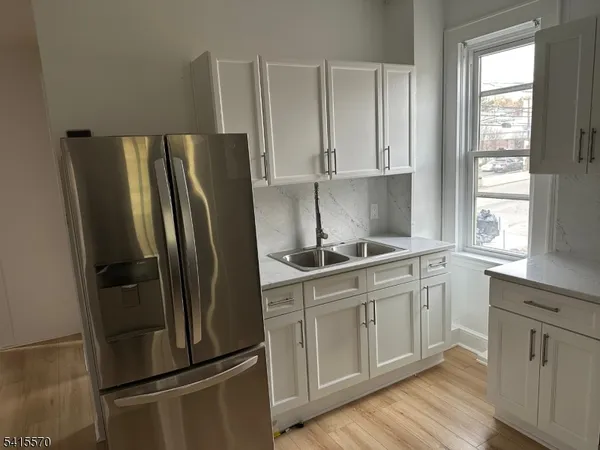 a kitchen with stainless steel appliances a refrigerator sink and cabinets