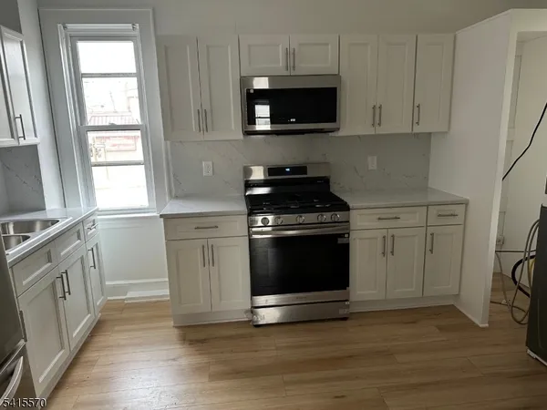 a kitchen with stainless steel appliances a stove a microwave and sink