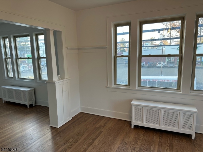186 Main Avenue Passaic, NJ 07055 - Photo 7 of 13 a view of an empty room with wooden floor and a window