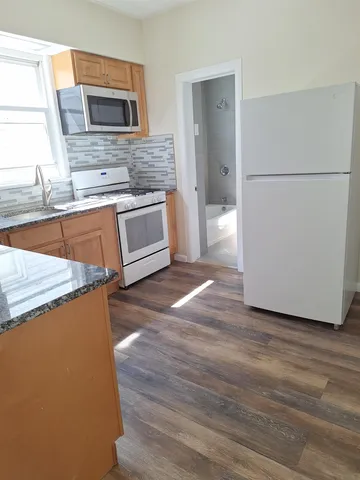 a kitchen with stainless steel appliances granite countertop a refrigerator a stove a sink and a microwave