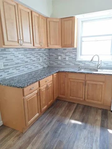 a kitchen with granite countertop stainless steel appliances sink and wooden cabinets