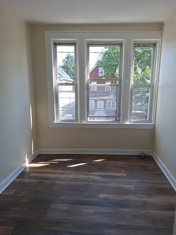 a view of a room with wooden floor and a window