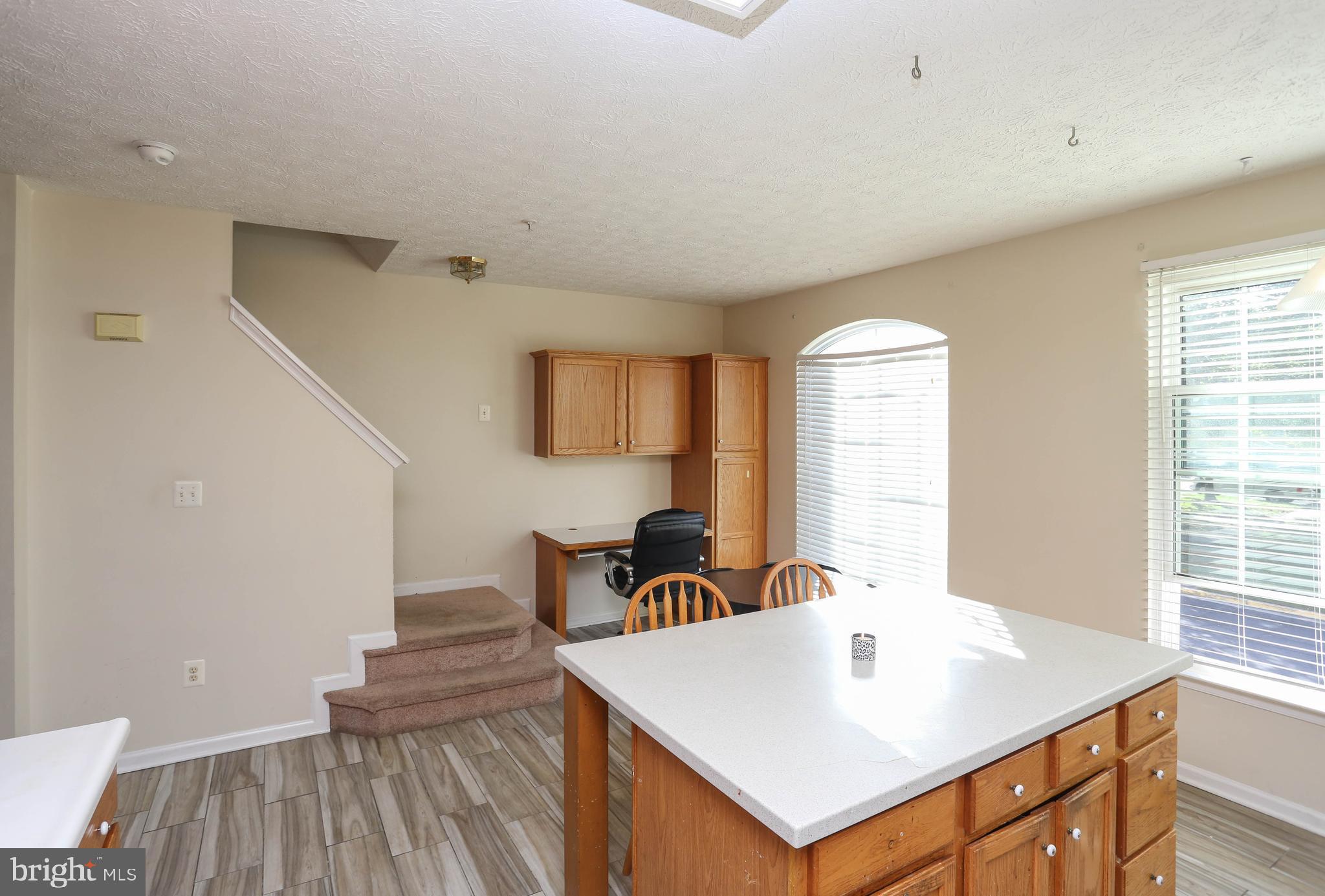 1734 Sea Pine Circle, Unit 136 Severn, MD 21144 - Photo 16 of 32 a view of kitchen island with furniture and wooden floor