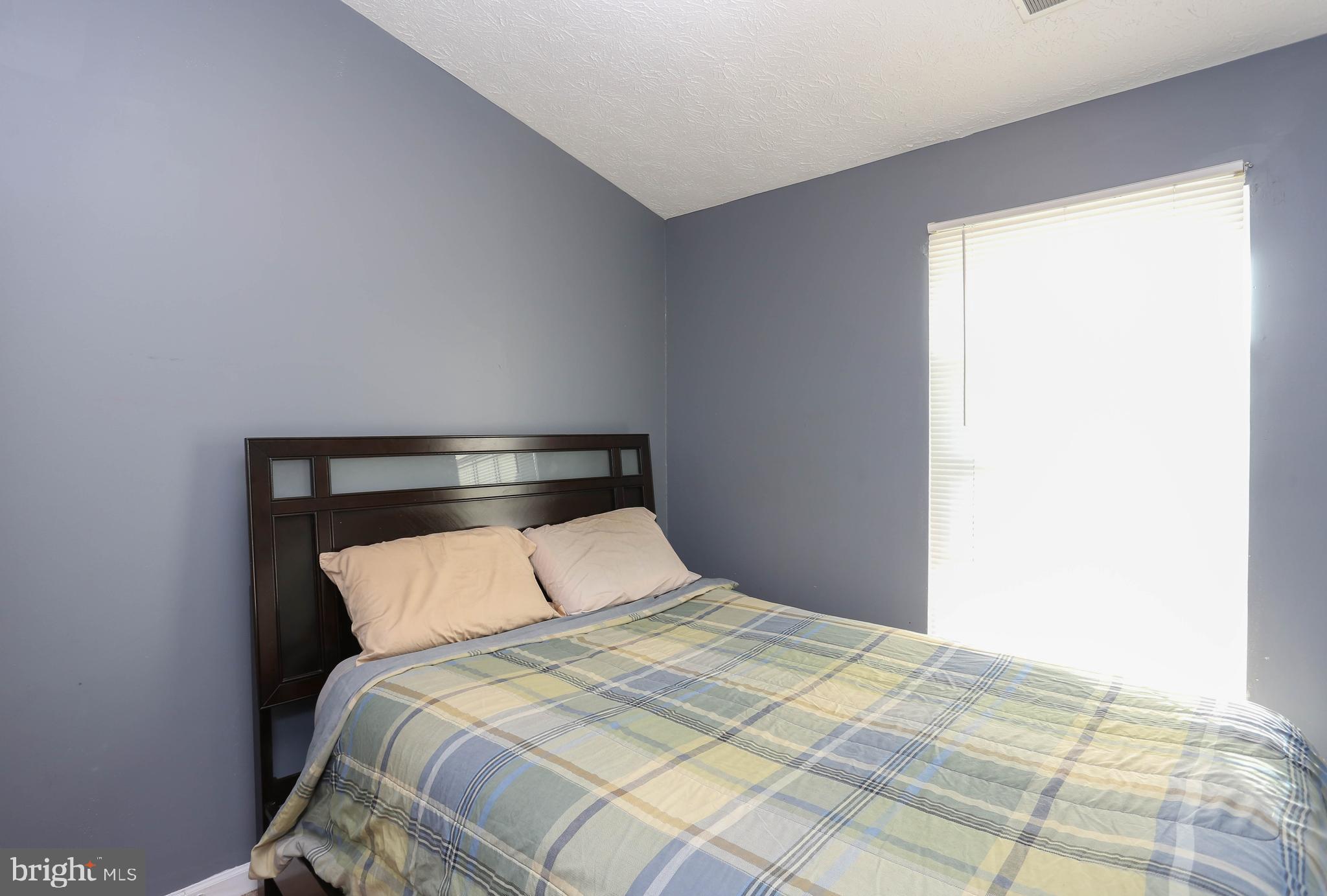1734 Sea Pine Circle, Unit 136 Severn, MD 21144 - Photo 25 of 32 a bedroom with a bed and a night stand