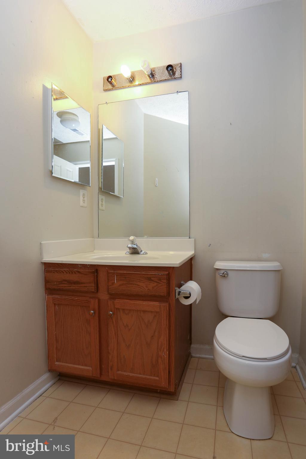 1734 Sea Pine Circle, Unit 136 Severn, MD 21144 - Photo 27 of 32 a bathroom with a toilet a sink and mirror