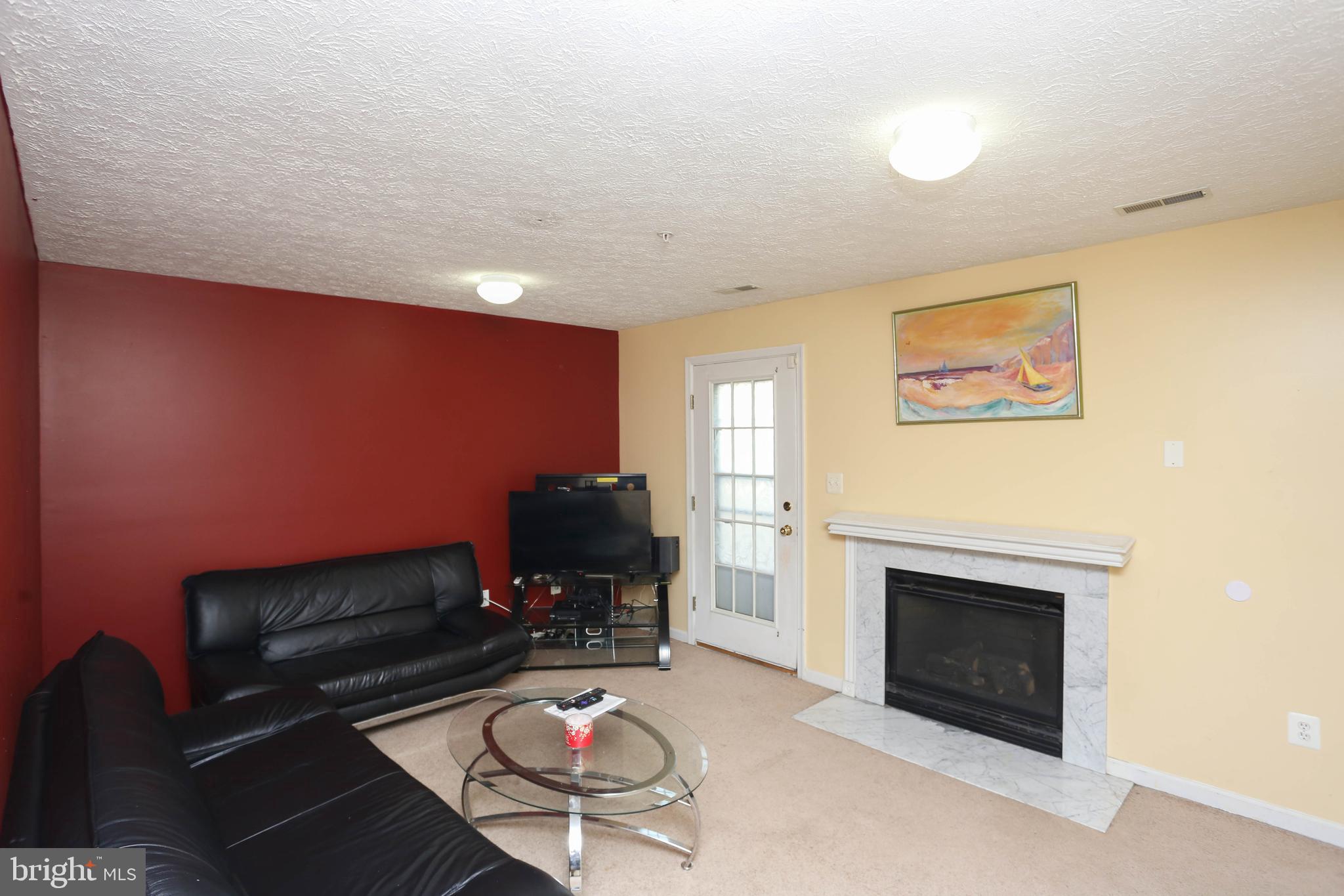 1734 Sea Pine Circle, Unit 136 Severn, MD 21144 - Photo 7 of 32 a living room with furniture and a fireplace