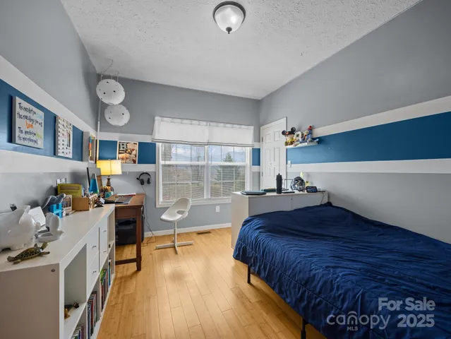 a bedroom with a bed and a wooden floor