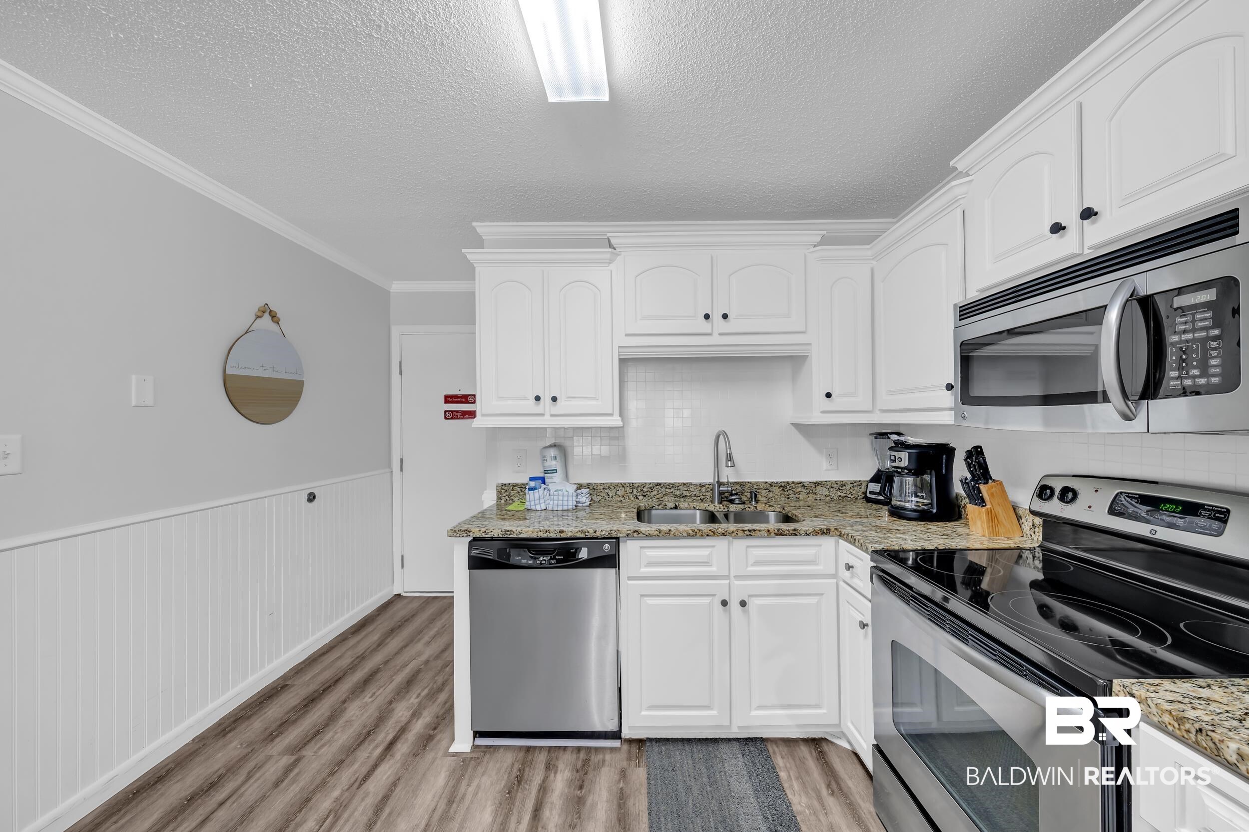 400 Plantation Road, Unit 2118 Gulf Shores, AL 36542 - Photo 9 of 59 Kitchen featuring white cabinetry, granite countertops, stainless steel appliances, and wood-finish flooring