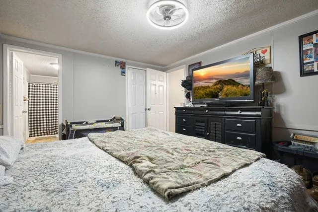 a bedroom with a bed and a flat screen tv