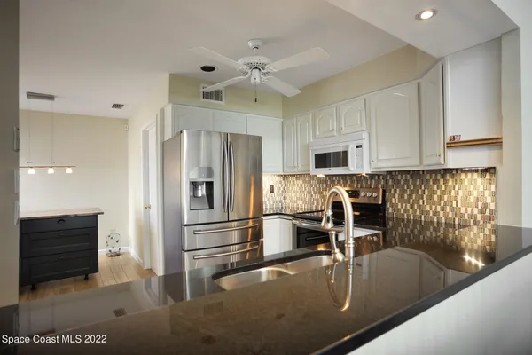 a kitchen with stainless steel appliances granite countertop a refrigerator and a stove top oven