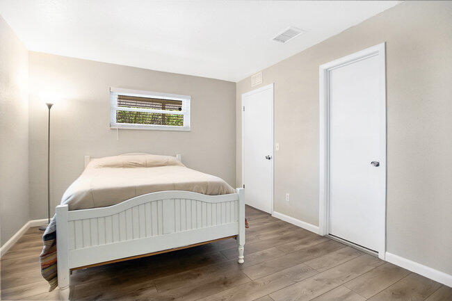 2879 Lancaster Road Melbourne, FL 32935 - Photo 11 of 28 a bedroom with a bed and wooden floor