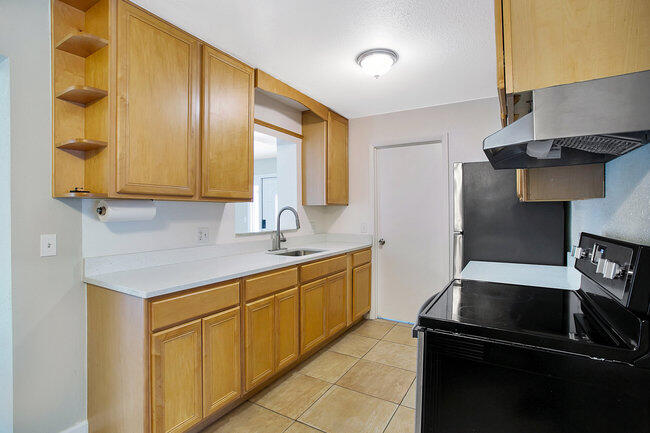 2879 Lancaster Road Melbourne, FL 32935 - Photo 5 of 28 a kitchen with a sink dishwasher a stove and a refrigerator