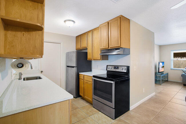 2879 Lancaster Road Melbourne, FL 32935 - Photo 7 of 28 a kitchen with stainless steel appliances granite countertop a sink stove and refrigerator
