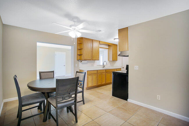 2879 Lancaster Road Melbourne, FL 32935 - Photo 8 of 28 a kitchen with a dining table chairs and sink