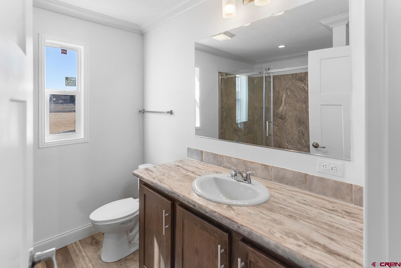 62650 Lasalle Road, Unit 330 Montrose, CO 81403 - Photo 16 of 23 a bathroom with a granite countertop sink a toilet and a mirror