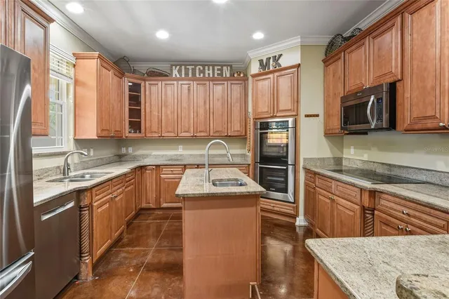 a kitchen with granite countertop a sink stove and refrigerator
