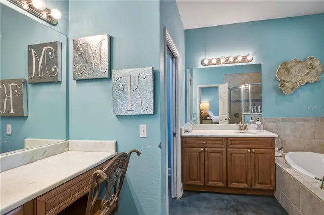 a bathroom with a granite countertop sink a toilet a large mirror and shower