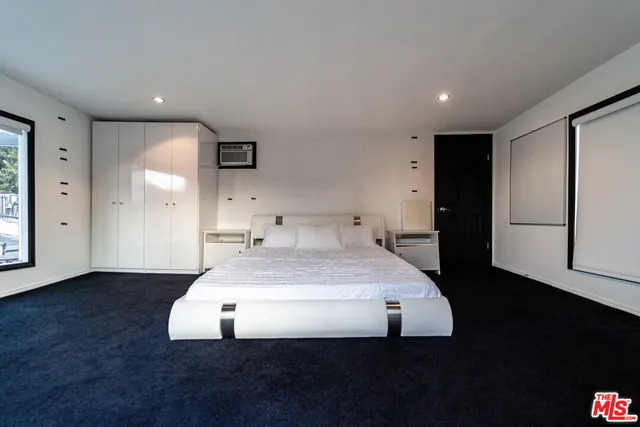 a spacious bedroom with a bed and a night stand