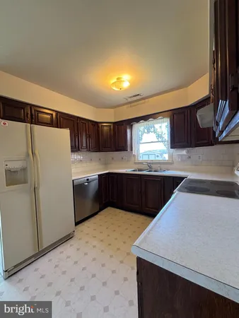 a kitchen with a sink a refrigerator and window