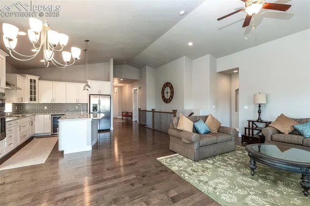 a living room with couches a fireplace and kitchen view