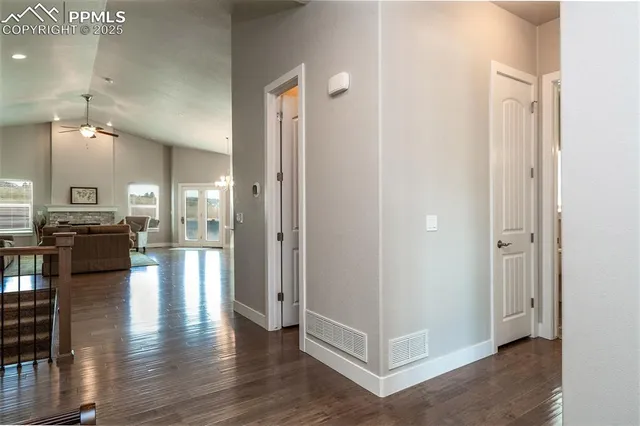 a view of a hallway with kitchen view and wooden floor