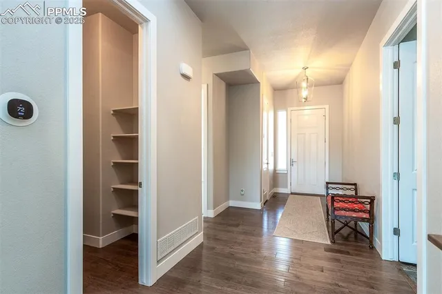 a view of a hallway with wooden floor and closet area