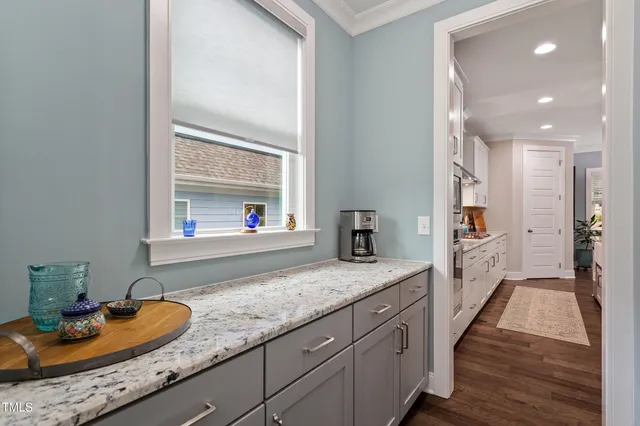 a hallway with sink and mirror with wooden floor