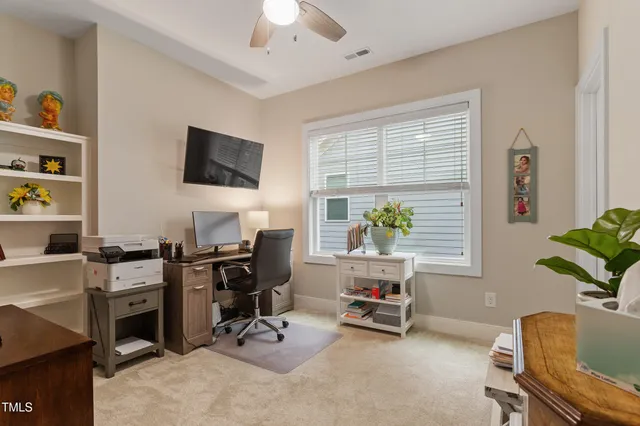 a view of a workspace with furniture and a window