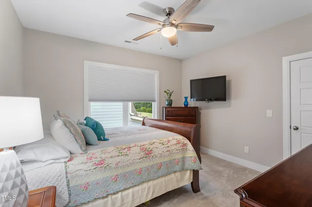 a bedroom with a bed window and a flat screen tv