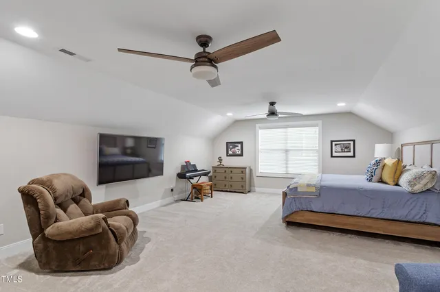 a spacious bedroom with a bed a couch and a chandelier