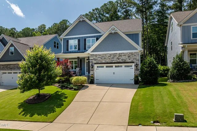 an aerial view of a house with a yard and a car park
