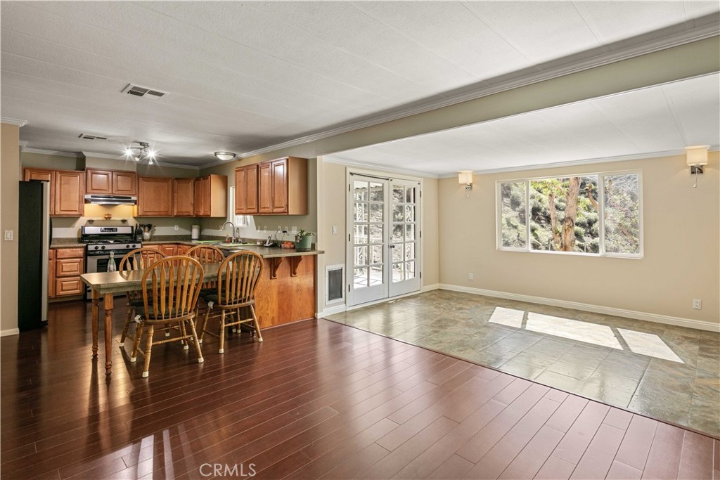 28274 San Martinez Grande Canyon Road Castaic, CA 91384 - Photo 27 of 48 a kitchen with stainless steel appliances granite countertop a stove top oven a sink a dining table and chairs with wooden floor