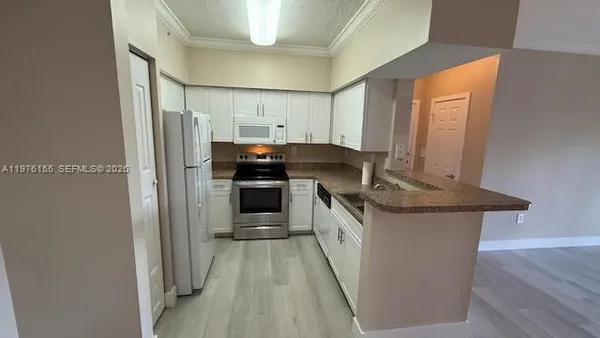 a kitchen with stainless steel appliances granite countertop a stove top oven a sink and a refrigerator