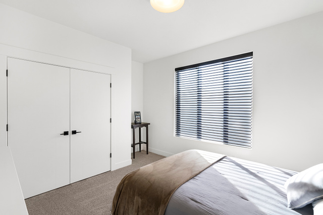 851 Grandview Drive Morgan, UT 84050 - Photo 25 of 68 Bright bedroom featuring neutral wall tones, a large window with horizontal blinds, textured carpet flooring, and a ceiling-mounted light fixture
