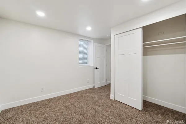 an empty room with windows and entrance to other room