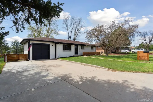 a view of a house with a yard and large trees