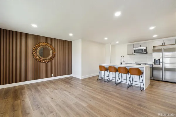 a view of kitchen with stainless steel appliances granite countertop a stove and a wooden floors