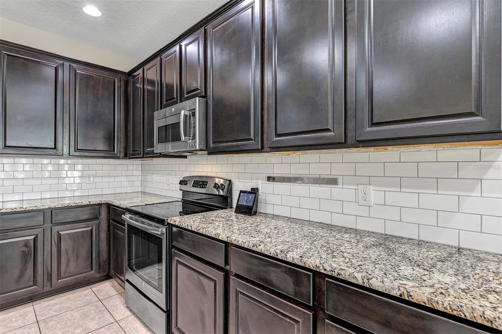 7644 Ripplepointe Way Windermere, FL 34786 - Photo 7 of 52 a kitchen with granite countertop stainless steel appliances and cabinets