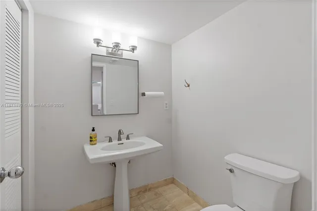 a bathroom with a sink toilet and mirror