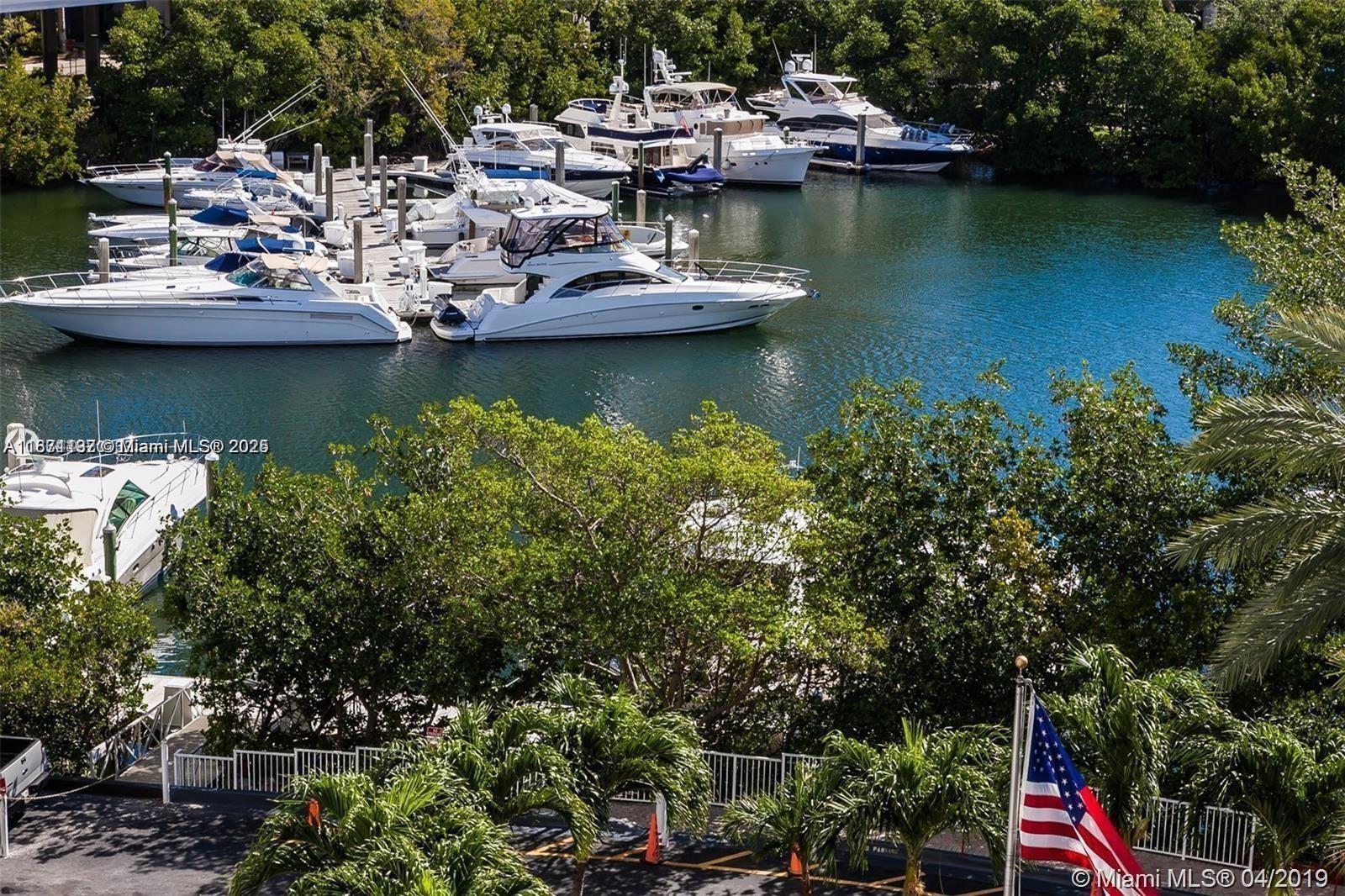 3600 Mystic Pointe Drive, Unit 215 Aventura, FL 33180 - Photo 31 of 49 a view of a lake with boats and trees in the background