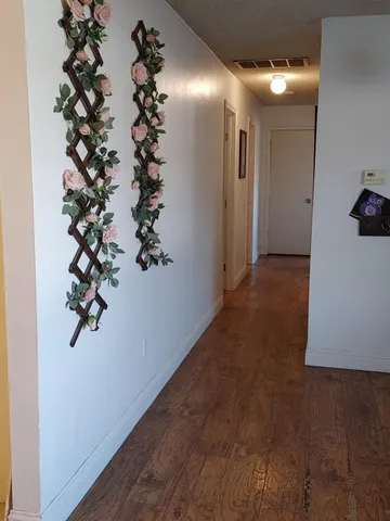 a view of a hallway with wooden floor