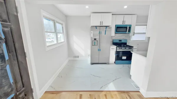 a kitchen with stainless steel appliances a refrigerator a stove a microwave and cabinets