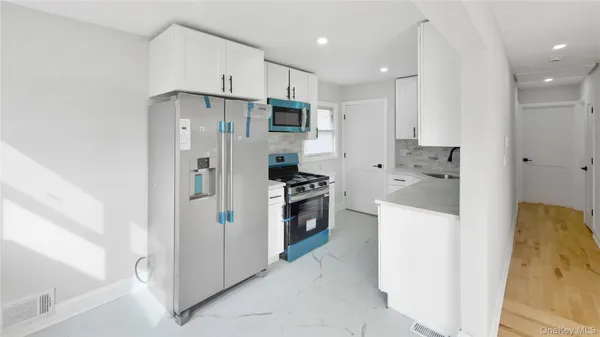 a kitchen with stainless steel appliances white cabinets and a refrigerator