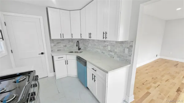a kitchen with granite countertop white cabinets and white appliances