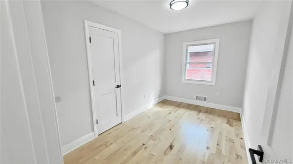 a view of a room with wooden floor and a window