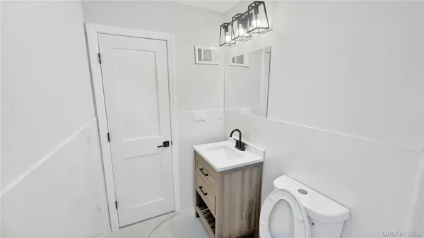 a bathroom with a sink a toilet and mirror