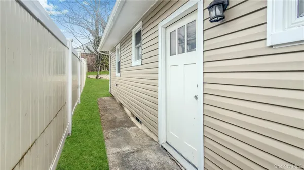 a view of a house with brick walls and a yard with plants