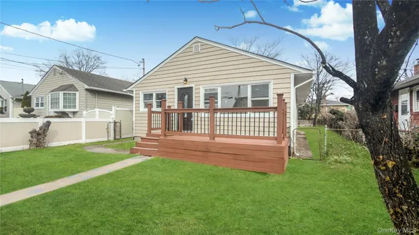 a view of a house with a yard and a large tree